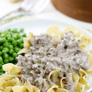 Hamburger Stroganoff on a white plate with peas.