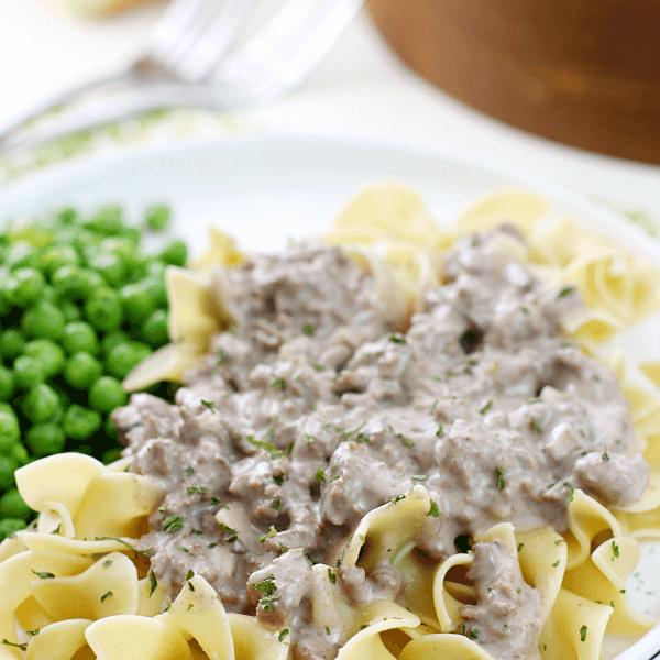 Hamburger Stroganoff on a white plate with peas.