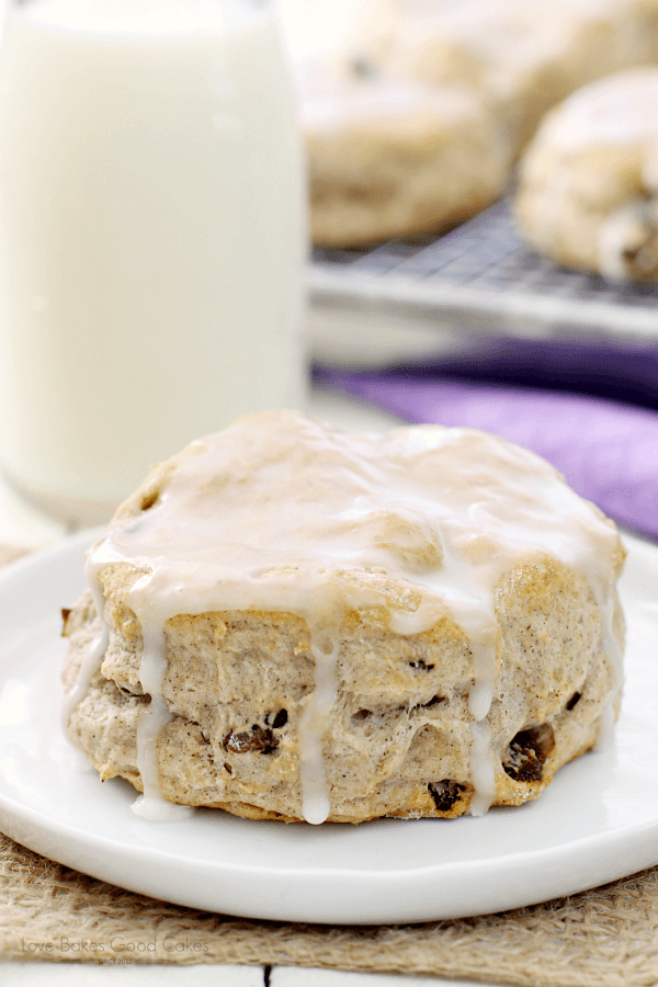 Cinnamon Raisin Biscuit on a white plate with a glass of milk.