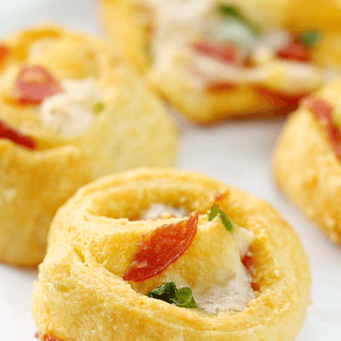 Pizza Pinwheels on a white plate, with a close up shown for texture.