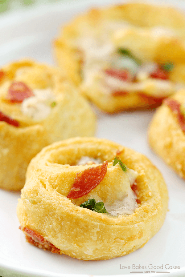 Pizza Pinwheels on a white plate, with a close up shown for texture.