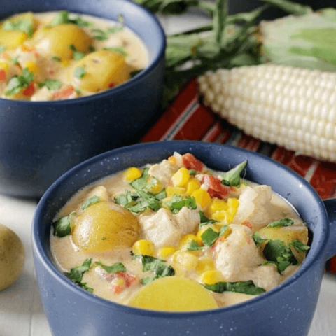 Mexican Chicken & Corn Chowder in two bowls with a spoon.