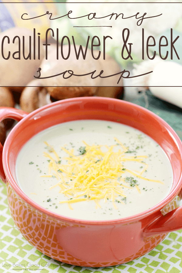 Creamy Cauliflower and Leek Soup in a red bowl with cheese.