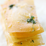 Garlic Parmesan Wonton Crisps stacked up on a piece of wax paper.