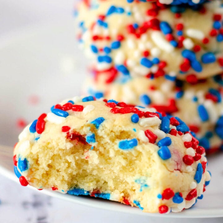 closeup of a sprinkle cookie with a bite taken out to show the inside texture
