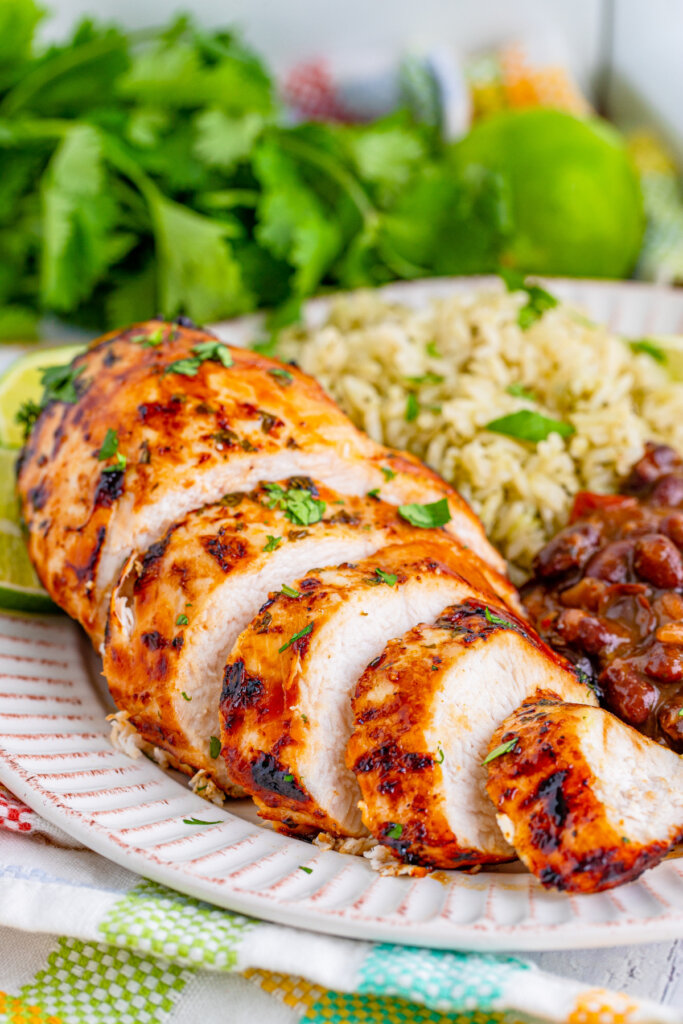 sliced air fryer margarita chicken on plate with rice and beans