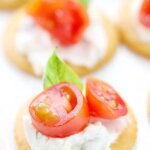 Ritz crackers with tomatoes and basil.