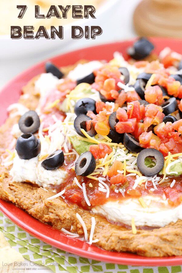 Beans with black olives and diced tomatoes on a plate for texture.