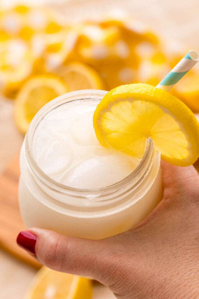 hand holding a glass of creamy lemonade