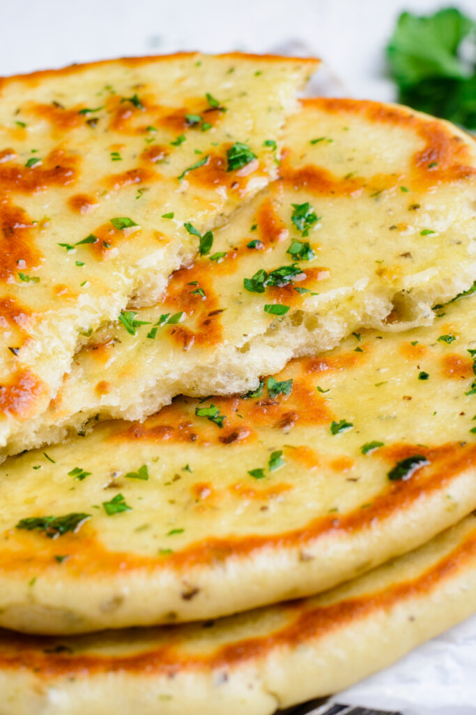 torn flatbread stacked on top of other flatbread