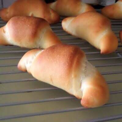 Golden brown rolls on a cooling rack.