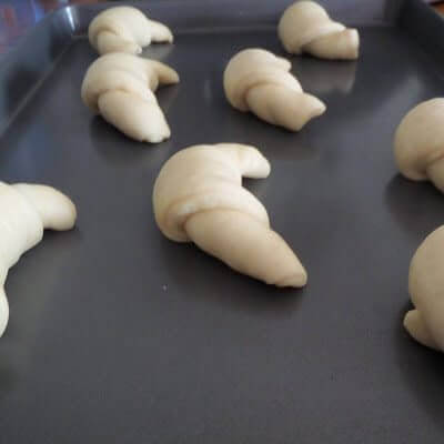 Fresh rolls on a baking sheet ready for the oven.