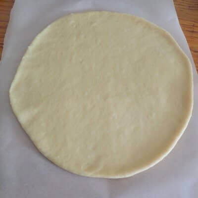 Rolling out the dough flat.
