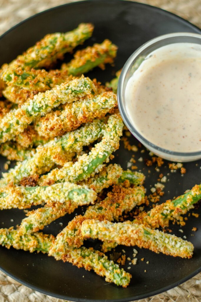 black plate with green bean fries and dipping sauce