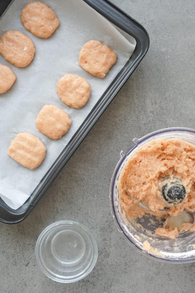 Scooping portions of the chicken mixture to shape homemade chicken nuggets.