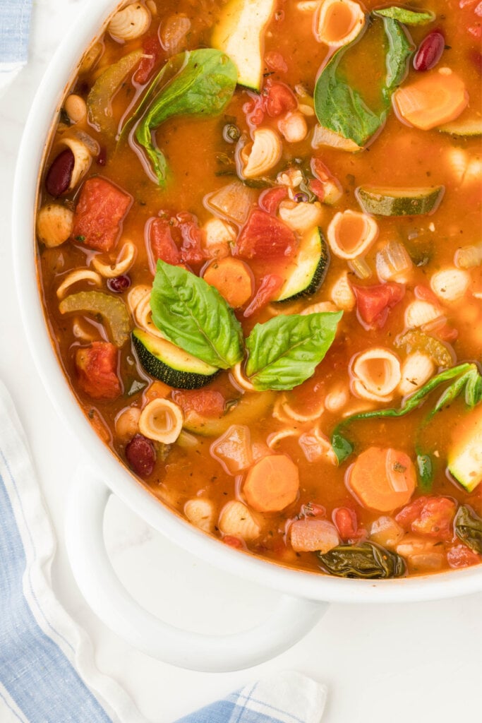 bowl of minestrone soup garnished with fresh basil