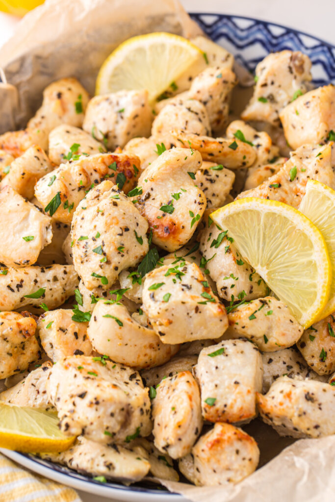 bowl with lemon chicken bites and lemon slices