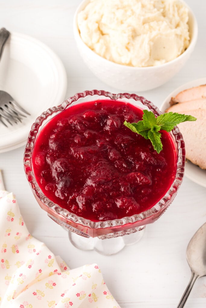 cranberry sauce in glass bowl garnished with mint