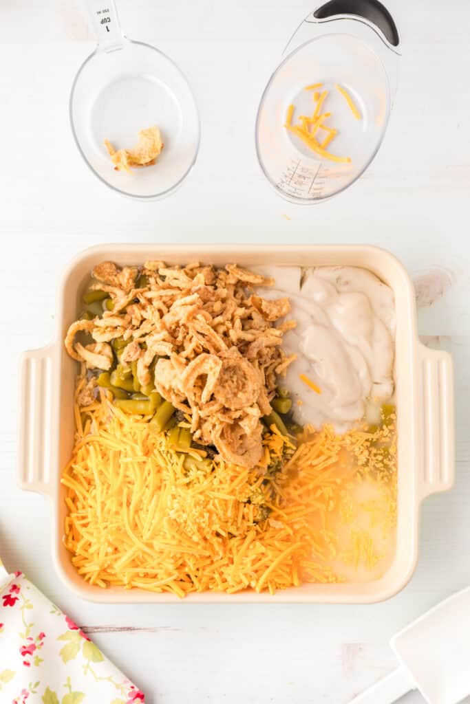 Green bean casserole ingredients arranged in a baking dish before being mixed together