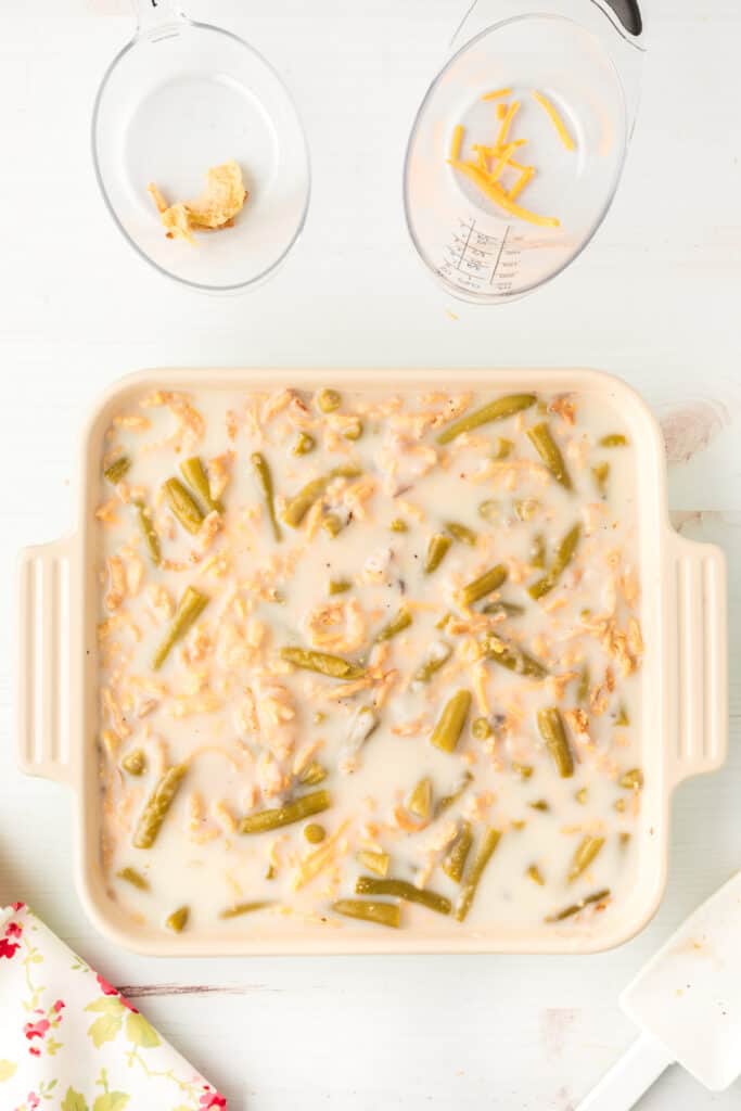 Green beans, creamy mushroom sauce, cheddar cheese, and crispy fried onions mixed together in a casserole dish