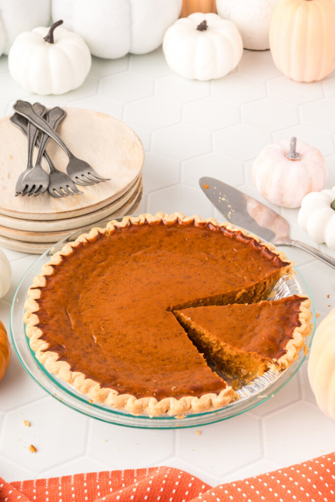 whole pumpkin pie with a slice cut