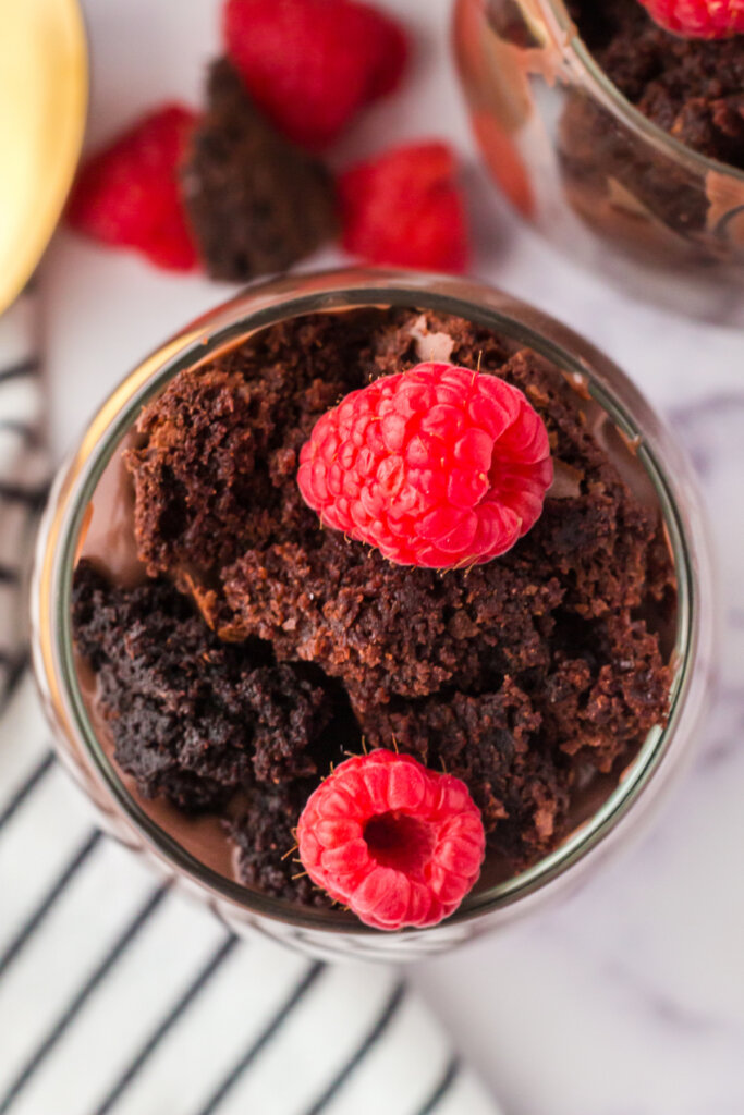 crumbled brownies, pudding, and raspberries in glass