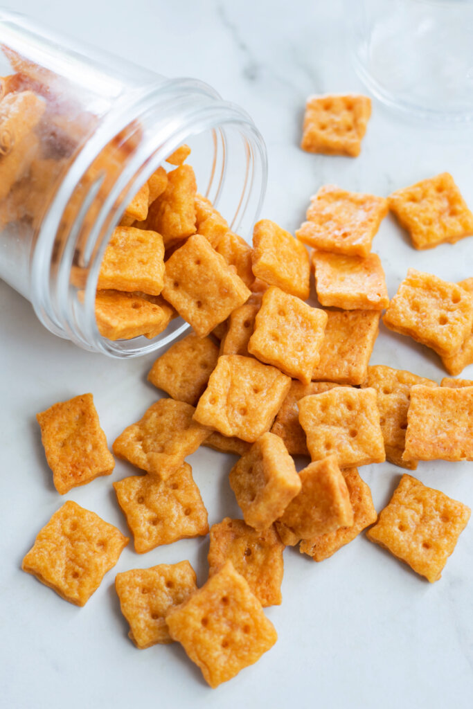 homeade cheese crackers spilling out of a glass jar