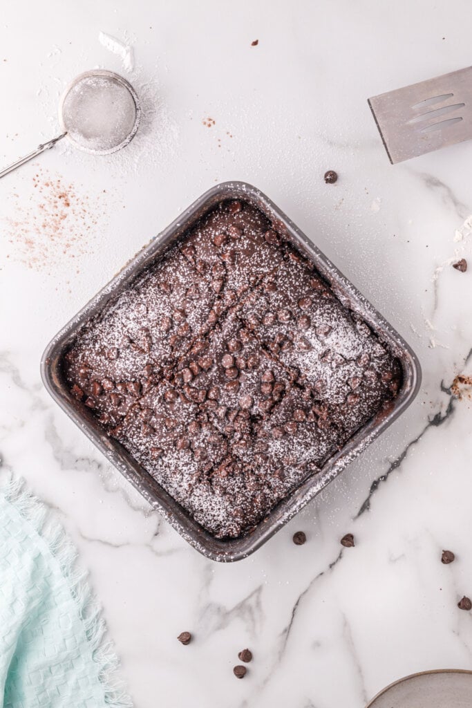 looking down onto baking pan with finished chocolate snack cake sprinkles with powdered sugar