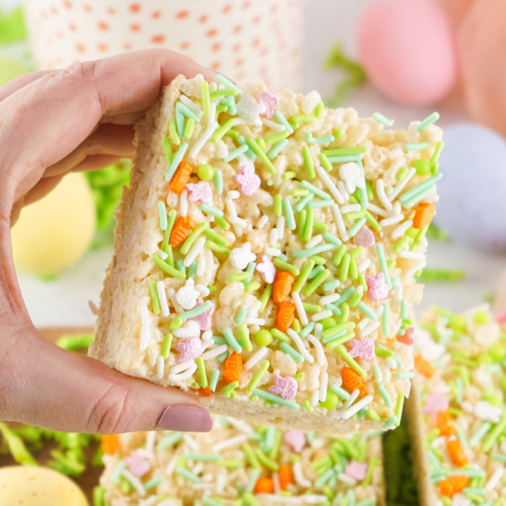 hand holding Easter Rice Crispy Treats are the perfect treat for spring. This recipe can easily be made allergy-friendly for a goody everyone can enjoy.