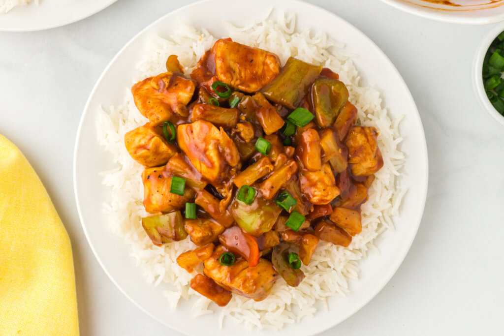 hawaiian chicken over rice on white plate