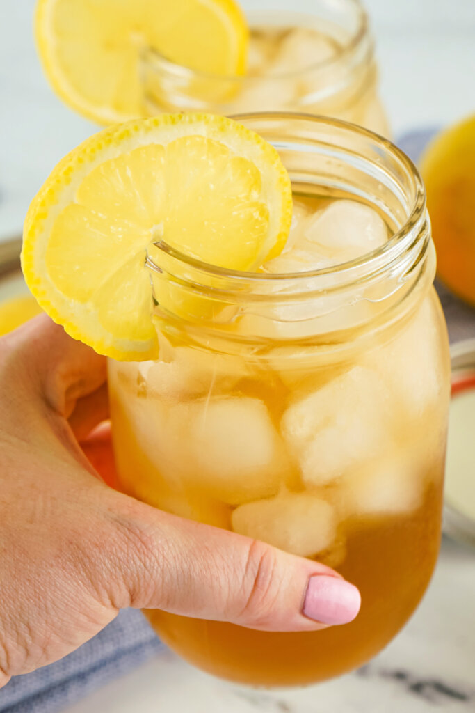 hand holding a glass mason jar filled with arnold palmer cocktail