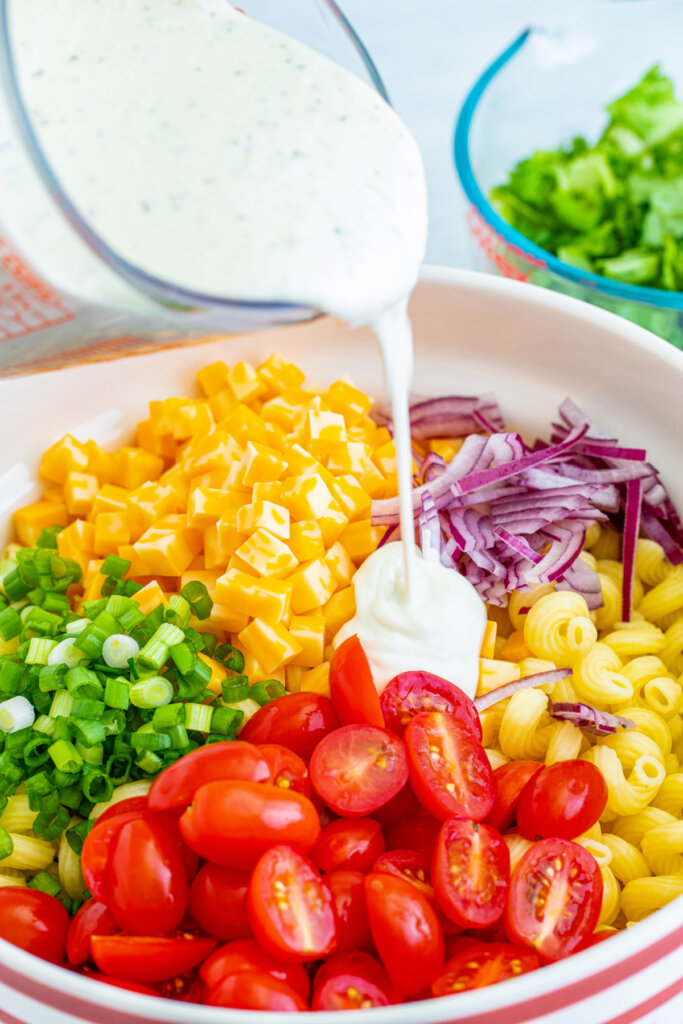 ranch blt pasta salad ingredients seprated in bowl beofre being mixed with dressing being poured over