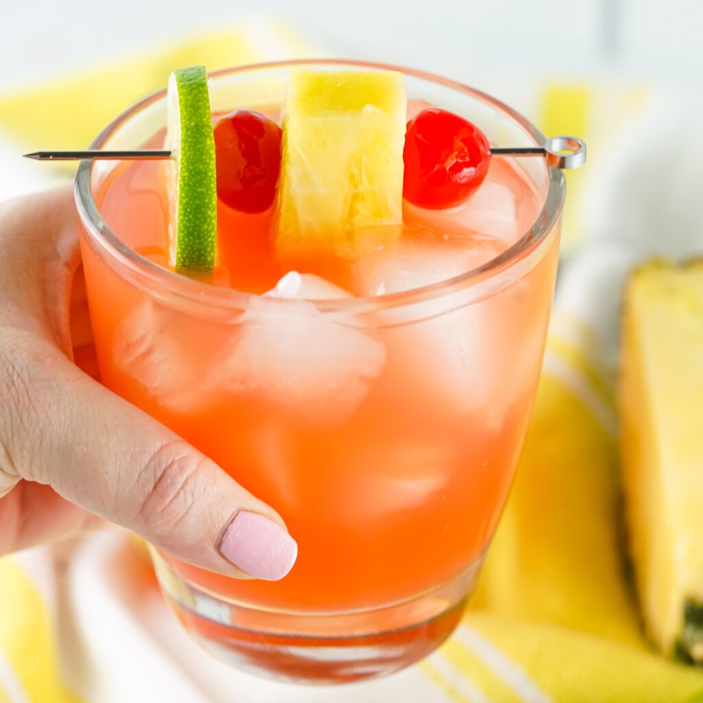 hand holding rum punch cocktail