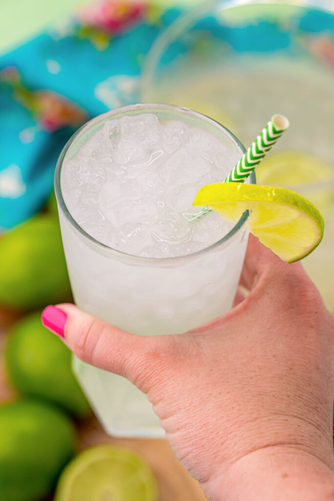 hand holding a glass of limeade