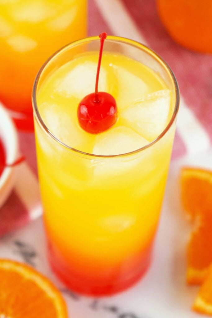tequila sunrise cocktail in glass garnished with cherry