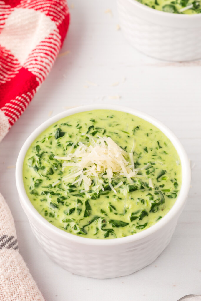 easy creamed spinach topped with parmesan cheese in bowl