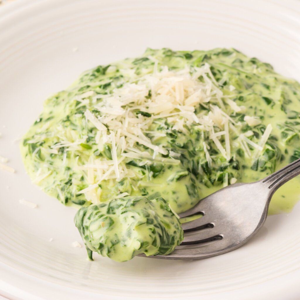 fork on plate with a scoop of creamed spinach