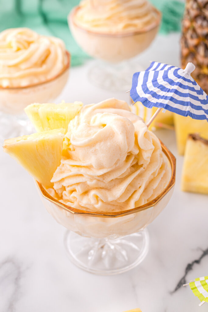 copycat disney dole whip with pineapple wedges and small drink umbrella