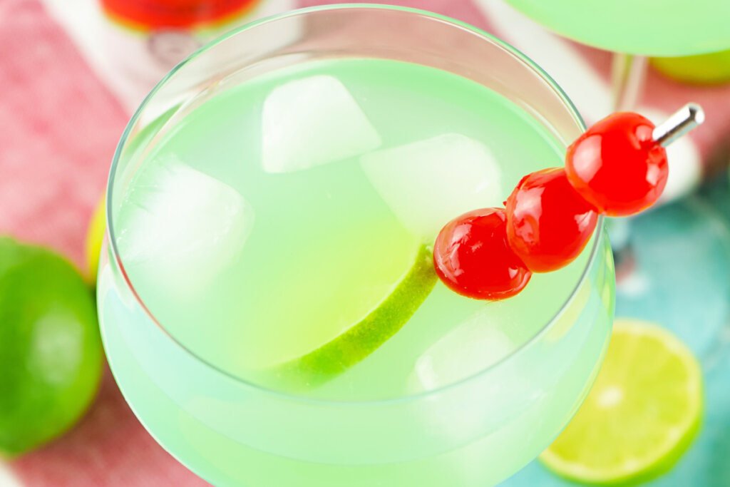 mermaid punch garnished with lime slice and maraschino cherries