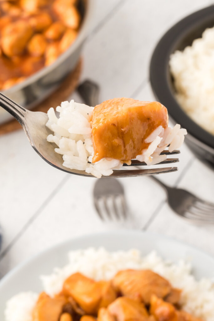 bourbon chicken with rice on a fork