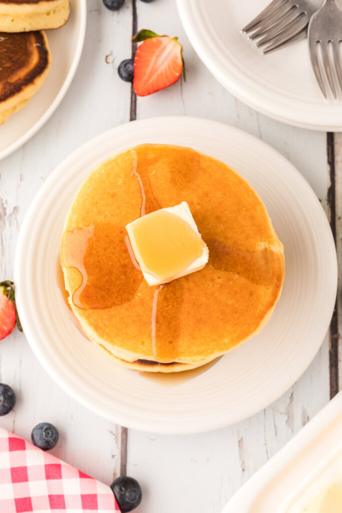 stack of buttermilk pancakes with a pat of butter and syrup