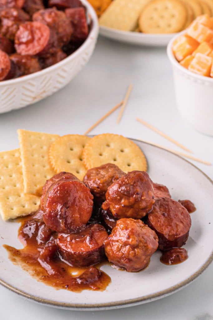 cranberry chipotle meatballs and sausage on plate with crackers