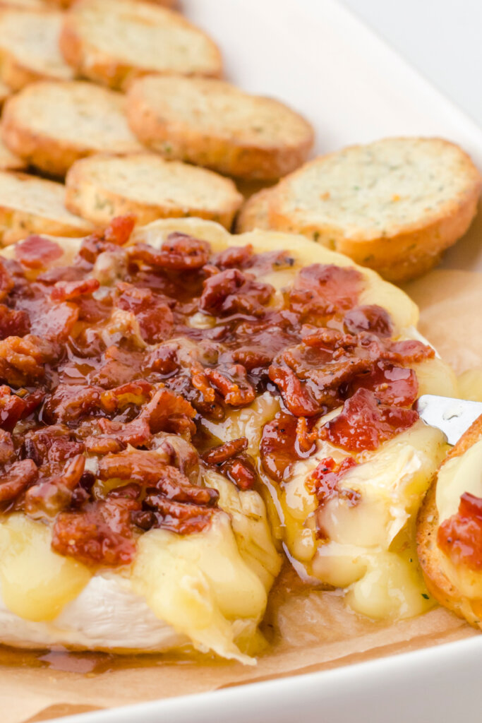 baked maple bacon brie cheese on baking sheet with bread slices