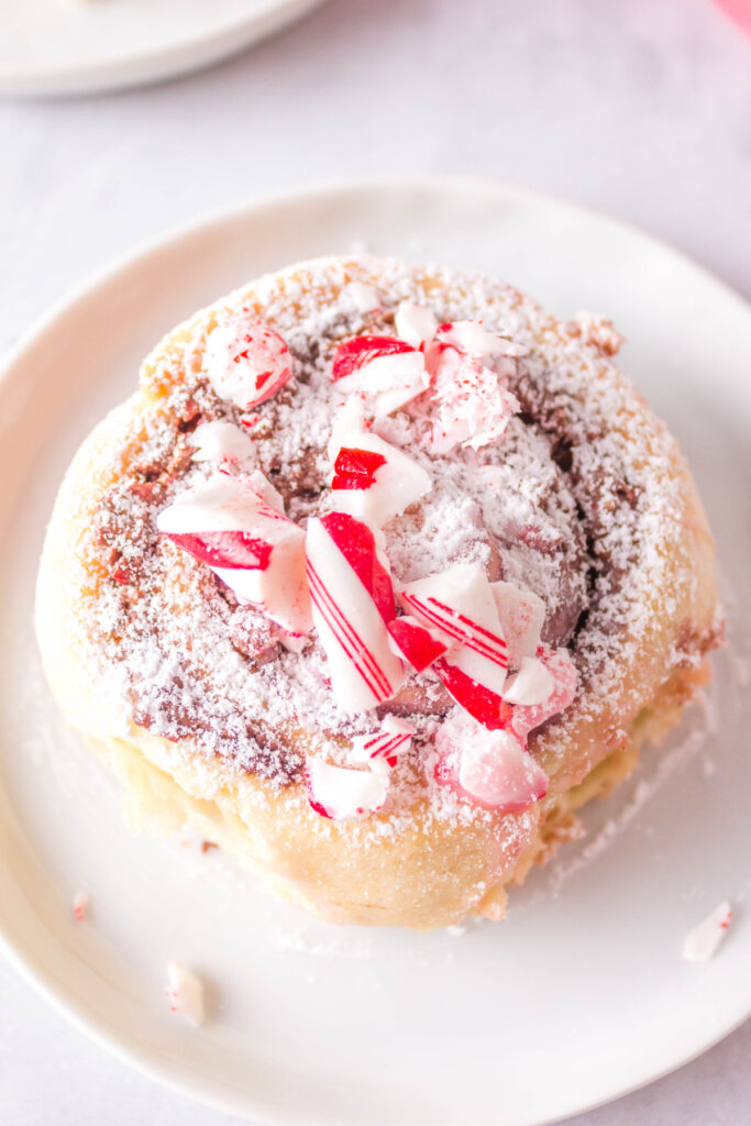 looking down onto a candy cane cinnamon roll on a plate