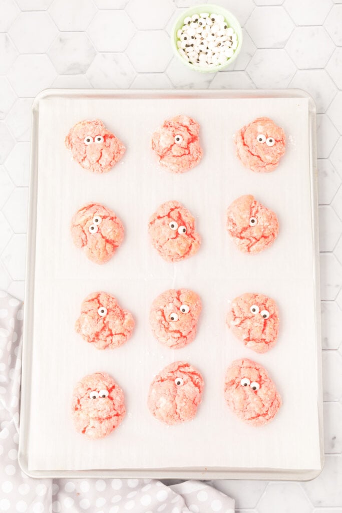 Baked pink cookies with candy eyeballs pressed on top to look like monster faces