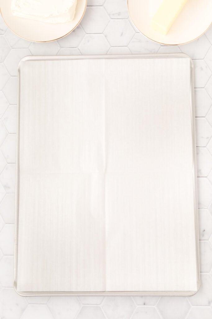 A baking sheet lined with parchment paper, ready for cookie dough
