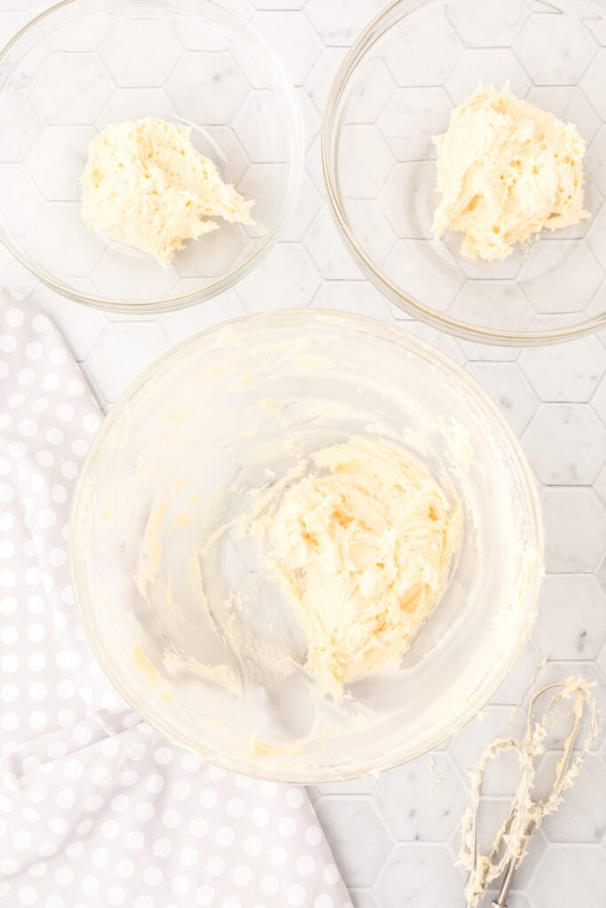 Cookie dough divided evenly into three separate glass bowls