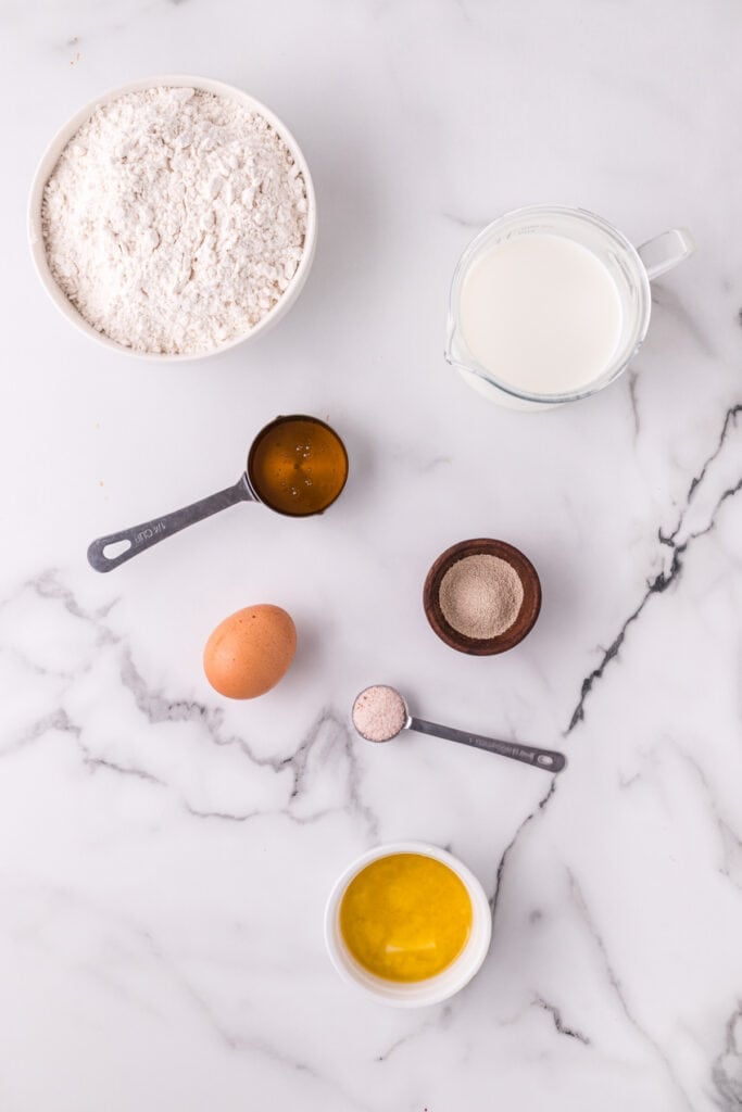 Ingredients for homemade Texas Roadhouse rolls arranged on a marble countertop