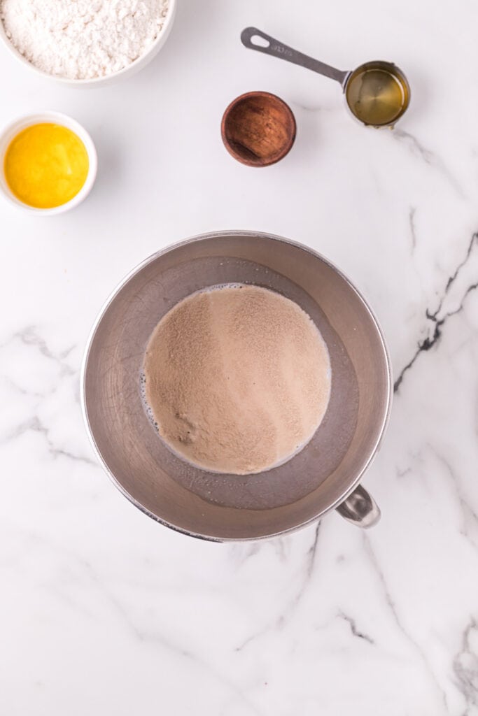 Yeast added to warm milk in a mixing bowl for homemade Texas Roadhouse rolls