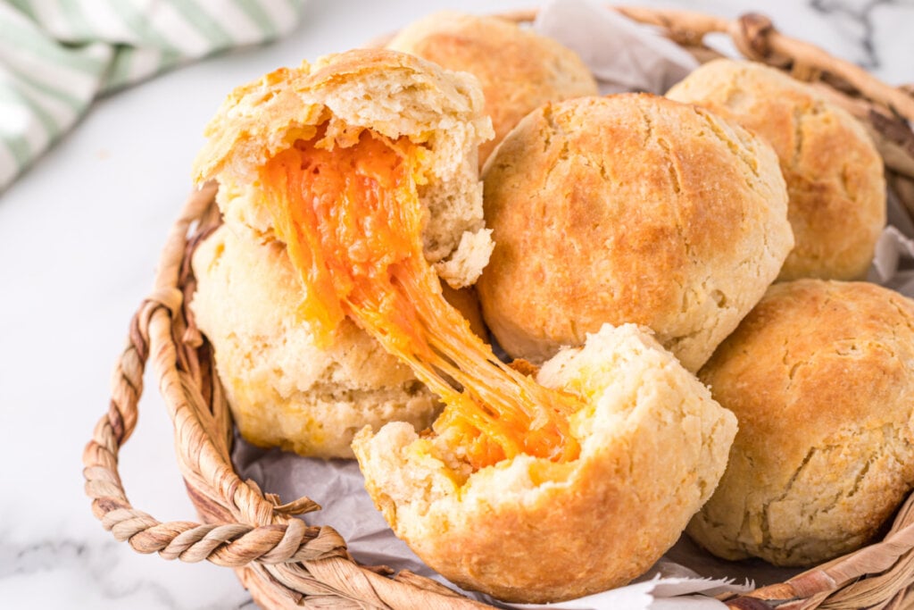 eastern nc cheese biscuits in basket with one open to show the melted cheese inside